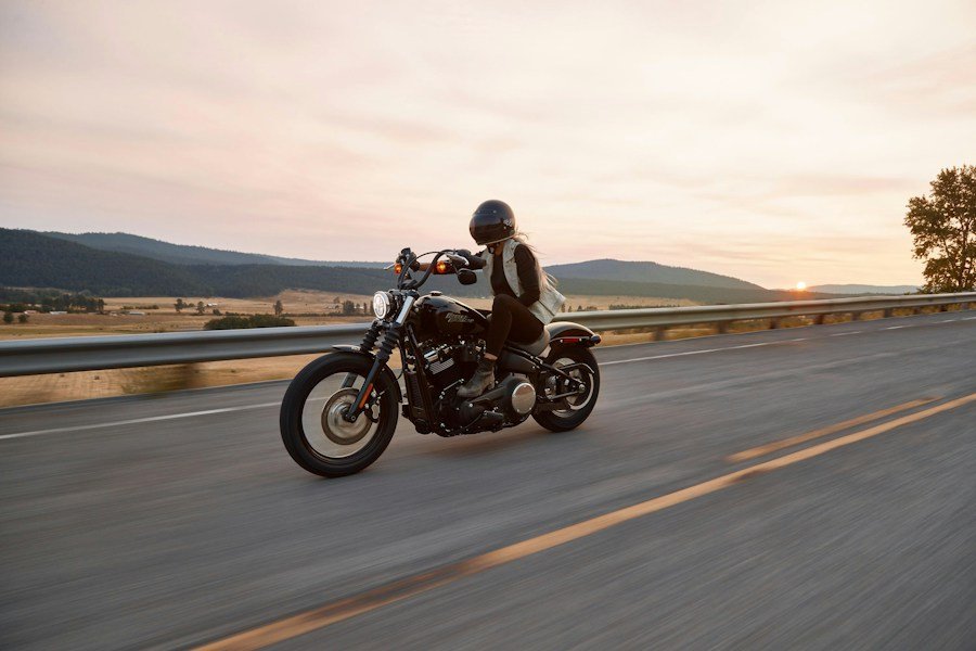 Motorcyclist riding along a country road at sunset